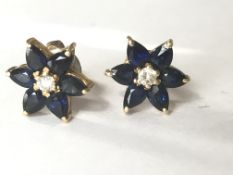 A pair of 18ct gold diamond and sapphire stud earrings of flower head form having a central