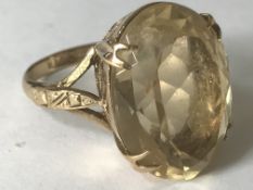 A hallmarked 9ct gold ring having a large central faceted citrine stone set in open gallery