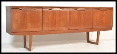 A 1970's retro vintage teak wood credenza sideboard comprising of four doors with lipped and pierced