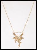 A hallmarked 9ct gold pendant necklace in the form of a fairy set to a 9ct gold Singapore link