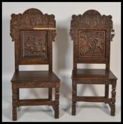 A pair of 19th century armorial carved oak hall / throne chairs each depicting scenes from Royal