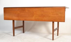 A Danish mid century teak wood dining table being raised on teak tapering legs united by returns