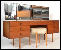 A vintage retro 20th century teak knee hole dressing table desk having a configuration of seven