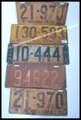 A collection of five vintage early 20th Century original American tin car registration / number