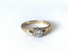 A hallmarked 18ct gold and diamond ring having raised pierced shoulders with illusion set diamond.
