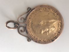 A 1913 full gold sovereign set within a 9ct rose gold pendant mount. Total weight 9.8g.