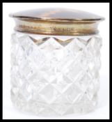 An early 20th century silver hallmarked and blonde tortoiseshell lidded cut glass dressing table pot