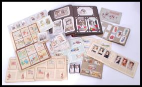 A collection of vintage cigarette cards along with a vintage greeting cards album. Please see