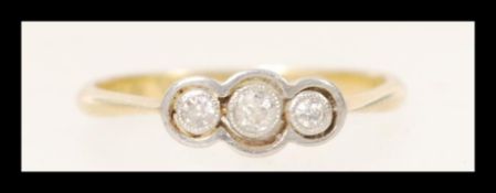An 18ct gold three stone diamond ring having three old cut diamonds in a white gold surround. Size
