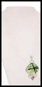A contemporary silver pendant necklace set with a Diolite panel and Amethysts. The chain in 18
