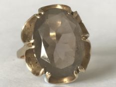 A hallmarked 9ct gold ring having large central smokey quartz stone set in an open prong mount.