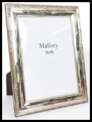 A large silver hallmarked picture photo frame retailed by Mallory Bath having an easel back.