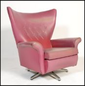 A mid century retro batwing swivel armchair in the manner of G-Plan having fabulous shape and