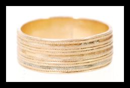 An 18ct gold yellow metal testing as 18ct gold band ring having a straight banded design. Weighs 4