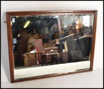 A vintage early 20th century large over mantel mirror having a central bevelled edge glass panel