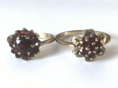 Two 9ct gold garnet cluster rings. One hallmarked London 1969 the other unmarked testing 9ct gold.