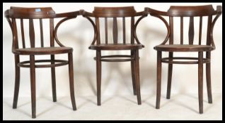 A set of three vintage retro 20th century Thonet type chairs having bowed armrests with circular