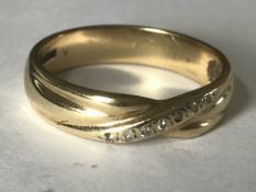 A hallmarked 9ct gold and diamond crossover band ring. Weight 3.7g. Size S.