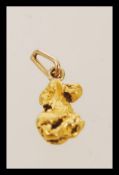 A pure gold nugget of natural rough form and texture with applied bale to make into a pendant. Total