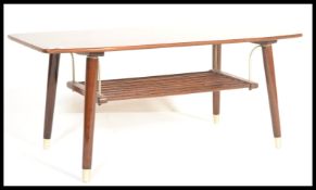 A vintage mid century coffee table with magazine rack underside on curved brass bars with brass