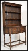 A 1920's oak Jacobean revival small dresser. Raised on bobbin turned legs united by stretchers