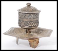 A continental silver desk inkwell having chased decoration raised in tripod feet with hexagonal tray