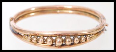A 9ct gold bangle bracelet having a split double band with graduating gold bead design. Weighs 11.