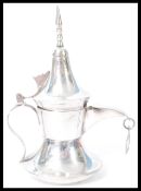 A sterling silver miniature model of a Dallah coffee pot having shaped handle and spout with
