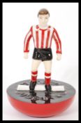 A Royal Doulton Subbuteo ceramic football figurine MCL 12 featuring a player in red and white