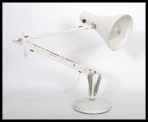 A vintage 20th century industrial anglepoise desk lamp raised on a circular base with pendant