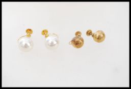 Two pairs of 9ct gold twist back earrings. One stamped 9ct the other testing as 9ct gold but filled.