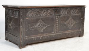An 18th century West Country oak coffer chest box being raised on stile legs with fielded panels