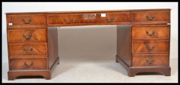 A Georgian style large mahogany and leather twin pedestal desk. Each pedestal with a bank of