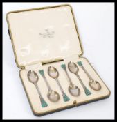 A set of six silver hallmarked and enamel teaspoons having acorn and leaf terminal handles with