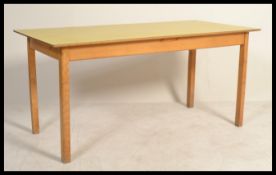 A large rare sized 1950's beach wood dining table formica yellow top and squared legs. Measures: