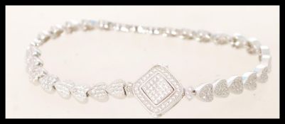 A sliver bracelet with cubic zirconia set with heart shaped bracelet links. The bracelet features