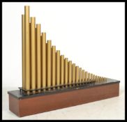 A mounted Organ speaker system by Conn. The mahogany and ebonised base with cylindrical brass tubing