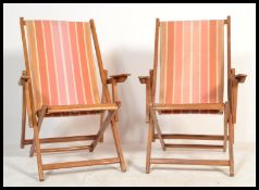A pair of retro mid 20th century wooden and canvas upholstered deck chairs. The slatted seats with