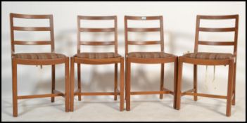 A set of 4 mid 20th century oak utility dining chairs. Each being raised on squared legs with