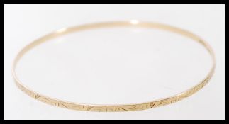 A hallmarked 9ct gold bangle bracelet having an engraved design. Weighs 4.6 grams.