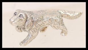 A contemporary 925 sterling silver figure of a dog in movement.