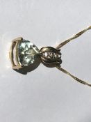 A 9ct gold pendant necklace strung with a pale green blue quartz and white stone set pendant on a