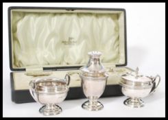 A cased silver hallmarked three piece cruet set by Walker and Hall. Hallmarked for Sheffield 1915.