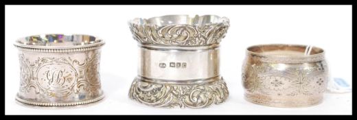 A group of three silver hallmarked napkin rings to include a large heavy example with relief