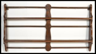 A vintage early 20th Century mahogany wall mounted plate rack in the manner of Ercol. Measures 57 cm