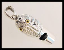 A contemporary sterling silver whistle pendant in the form of a frog with yellow and black glass