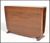 An Ercol Windsor pattern Golden Dawn drop leaf side table of beech and elm construction raised on