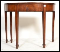 A 19th century George III mahogany demi - lune console table being raised on squared tapering legs