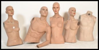 A collection of vintage realistic torso shop mannequins including four female and one male. The