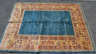 A 20th century Islamic Persian floor carpet rug having a blue ground with a cream main border and